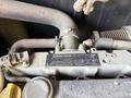 Close-up view of a 2015 JLG 450AJ engine component with a visible label and various pipes connected to it