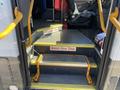 A set of yellow steps leading into the cabin of a 2020 Chevrolet Express with caution signs stating Watch Your Step