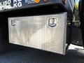 A silver aluminum storage box mounted on the side of a 2015 RAM 5500 truck with two handles and textured surface