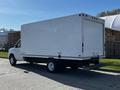 A white 2019 Ford Econoline box truck with no visible logos parked with its rear doors closed and a step bumper attached