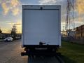 Rear view of a white 2017 Isuzu NPR truck with a closed box cargo area