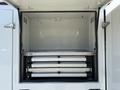 An empty storage compartment of a 2023 Ford F-550 featuring four metal drawers for organizing tools and equipment