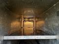 Interior view of a metallic cargo box showing a flat floor with a smooth texture and some water pooling on the surface