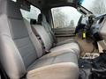 Interior view of a 2009 Ford F-550 showing two gray fabric seats with a dashboard and steering wheel visible in the foreground