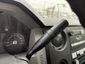 Close-up of the gear shift lever inside a 2013 Ford F-550 showing the various control knobs and gauges on the dashboard