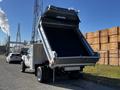 A 2008 Ford F-450 Super Duty dump truck with its bed raised for unloading materials