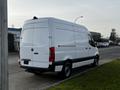 A white 2022 Mercedes-Benz Sprinter van parked on the street with a high roof and rear doors closed