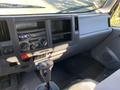 Interior dashboard of a 2015 Isuzu NPR featuring control panel radio knobs gear shift and storage compartments