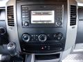 A 2016 Mercedes-Benz Sprinter dashboard featuring a central touchscreen display with radio and system controls along with climate control knobs and gear shift lever