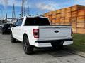 A 2021 Ford F-150 in white with a distinctive rear design showcasing the Ford logo and F-150 text