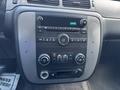 A dashboard control panel from a 2011 Chevrolet Avalanche featuring audio controls climate controls and a digital clock display