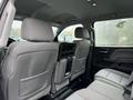 Interior of a 2015 GMC Sierra 1500 showing rear seating with gray fabric upholstery and a center console
