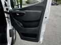 The interior door panel of a 2020 Mercedes-Benz Sprinter featuring a black texture handle and storage compartment