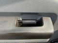 Close-up of the door handle of a 2011 Ford F-350 SD showing a textured black surface and a recessed pull mechanism
