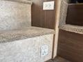 Interior steps of a 2018 Westland Travelaire with plush carpet covering and a power outlet visible on the wall