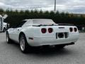 A white 1992 Chevrolet Corvette convertible with a soft top and distinctive rear lights showcasing a classic sporty design