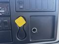Close-up of the dashboard of a 2018 International DuraStar featuring a yellow square button and several control switches