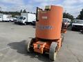 A 2009 JLG E300AJP electric boom lift featuring a large orange platform and wheels designed for elevating workers to heights for construction or maintenance tasks