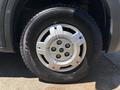 Close-up of a silver wheel with five spokes mounted on a black tire featuring a tread pattern labeled as "Hankook"