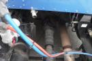 View of the drivetrain components of a 2015 Kenworth T660 including visible shafts and hoses in blue and red colors