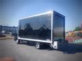 A 2013 Mitsubishi Fuso FE 160 box truck with a shiny black exterior and a large cargo space in the back parked on a lot