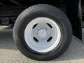 Close-up of a white-painted wheel with a black tire from a 2013 Ford Econoline