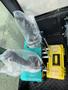 A 2024 AGT Industrial Green QH13R Mini Excavator's control panel featuring two levers covered in plastic and a yellow tool box on the side