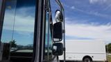 A 2011 Ford Econoline seen from the side showcasing its large side mirror and window near the driver's seat