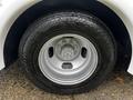 Close-up of a silver alloy wheel with a black tire marked Encounter AT and visible lug nuts