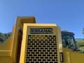 A yellow 2022 TerraMac tracked dump truck with a prominent grill and logo displayed on the front cabin