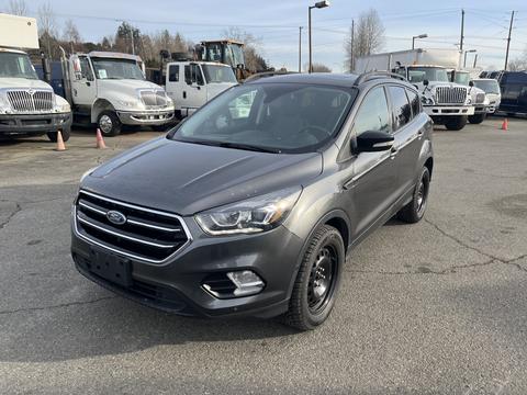 A gray 2019 Ford Escape is parked with a sleek design featuring a prominent front grille and black wheels