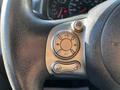 Close-up of the steering wheel controls in a 2017 Nissan NV200 featuring buttons for volume and media source selection