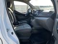 Interior view of a 2017 Nissan NV200 showing front seats and dashboard with a simple layout and fabric upholstery