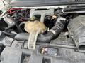 A close-up view of the engine compartment of a 2012 Chevrolet Express showing various engine components and hoses