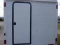 A white 2004 Royal 18 Foot Office Trailer with a black framed door in the center of the rear panel
