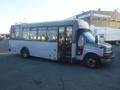 A 2016 Chevrolet Express bus with a gray exterior and large windows parked at a facility