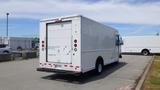 A 2011 Ford Econoline with a white box body and markings indicating it is a hybrid electric vehicle