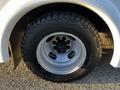 A close-up view of a black and silver tire mounted on a 2017 Chevrolet Express showcasing detailed tread and a multi-bolt wheel design