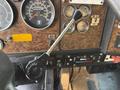 The interior dashboard of a 1996 Kenworth T800 showing gauges a gear shift lever and various control buttons