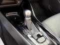 Close-up of the gear shift and console of a 2021 Toyota C-HR featuring a sleek design with a chrome knob and a leather-wrapped shift boot