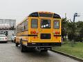 A yellow 2013 International 3000 school bus viewed from the rear showing its distinctive design and lights