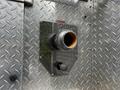 Close-up of a chrome fire hose connection with a black valve handle on a metal panel featuring a diamond plate texture