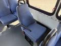 A blue upholstered seat with armrests in a vehicle interior designed for passenger transportation