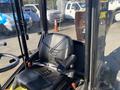 Black seat inside a 2010 Kubota F3680 tractor with controls visible and a clear view of the cabin's interior