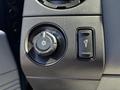 A close-up view of the dashboard controls of a 2014 Ford F-250 SD featuring a headlight dial and a fog light button