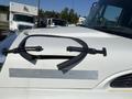 A white 2007 International 7300 truck's hood with a partially open access panel secured by rubber straps