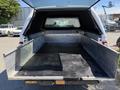 A 2014 Ford F-250 SD with an open pickup bed featuring metal side rails and a lined rubber floor