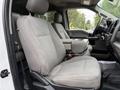 Interior view of a 2020 Ford F-550 showing a gray fabric front seat with a center console and armrest