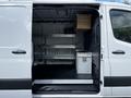 A 2020 Mercedes-Benz Sprinter van with an open sliding door showing interior shelving and storage compartments