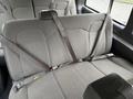 The image shows the interior rear bench seat of a 2023 GMC Savana equipped with seat belts and designed for passenger comfort and safety